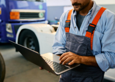 Truck mechanic working on laptop