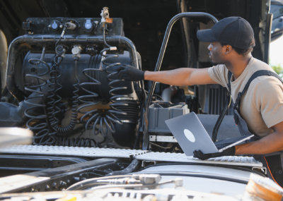 Truck repair service. Mechanic makes computer diagnostic of the semitruck.